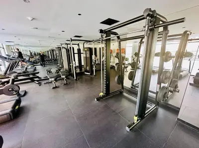 a gym with several tread machines and people in it at Dubai Arjan Studio - Near Miracle Garden, Hills Mall & Attractions in Dubai