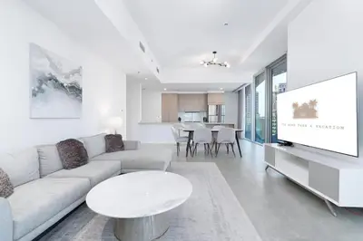 a white living room with a couch and a tv at Elegant Living in the Heart of Dubai Marina in Dubai