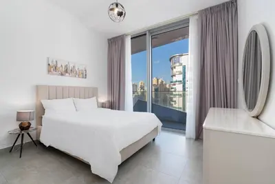 a bedroom with a white bed and a large window at Elegant Living in the Heart of Dubai Marina in Dubai