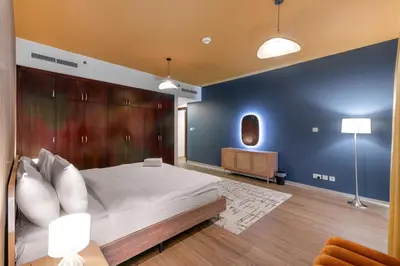 a bedroom with a large bed and a wooden wall at Marina Tower Residences by Baytna in Dubai