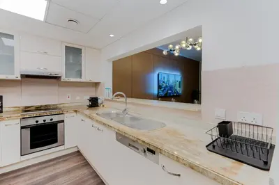 a kitchen with a sink and a counter top at Marina Tower Residences by Baytna in Dubai