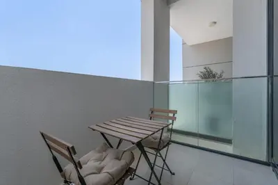 a table and two chairs on a balcony at AirDXB - Chic Studio Apartment in Meydan Sleeps 2 with Balcony in Dubai