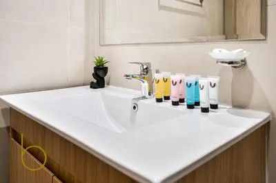 a bathroom sink with four different colored bottles on it at Bookable - Alexis Tower, Studio Room with Balcony in Dubai