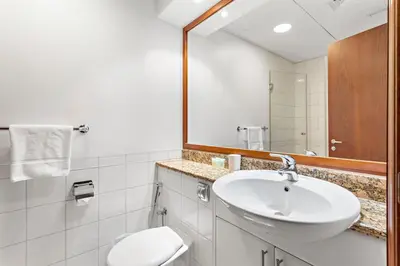 a bathroom with a sink and a toilet and a mirror at Sleek and Spacious 2BR at Dubai Marina, Near Beach in Dubai