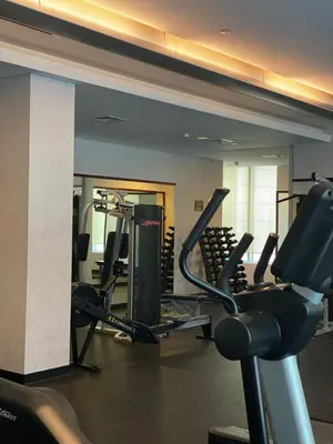 a gym with several tread machines in a room at Sleek and Spacious 2BR at Dubai Marina, Near Beach in Dubai