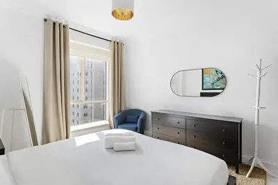 a bedroom with a bed and a tv and a chair at Sleek and Spacious 2BR at Dubai Marina, Near Beach in Dubai