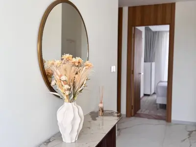 a vase of flowers on a table in front of a mirror at 3BR Luxury Townhouse with Garden in Dubai