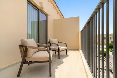 two chairs sitting on the balcony of a building at 3BR Luxury Townhouse with Garden in Dubai