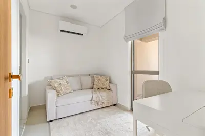 a white living room with a couch and a window at 3BR Luxury Townhouse with Garden in Dubai