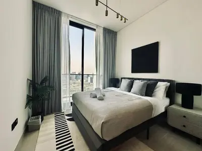 a bedroom with a large bed and a large window at Abstract 1br Flair Gym Pool And Free Parking! in Dubai
