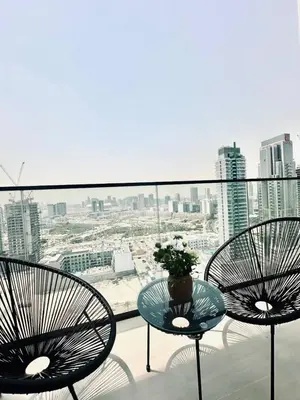 two chairs and a table on a balcony with a view at Abstract 1br Flair Gym Pool And Free Parking! in Dubai