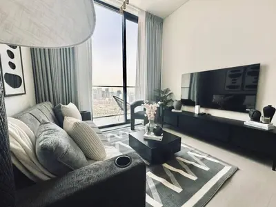 a living room with a couch and a flat screen tv at Abstract 1br Flair Gym Pool And Free Parking! in Dubai