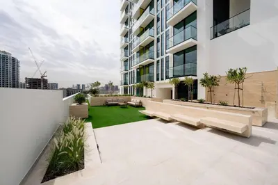 an apartment patio with benches and a lawn at Abstract 1br Flair Gym Pool And Free Parking! in Dubai