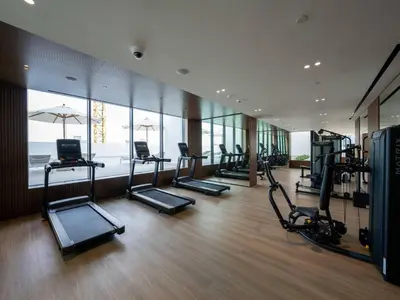 a gym with several treadmills and machines in a room at Abstract 1br Flair Gym Pool And Free Parking! in Dubai