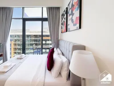 a bedroom with a white bed and a large window at Serenity Studio with Balcony at Azizi Riviera in Dubai