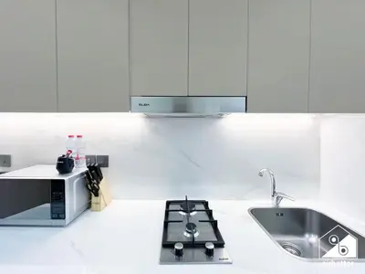a white kitchen with a sink and a microwave at Modern Comfort Studio Relax & Unwind in Style in Dubai