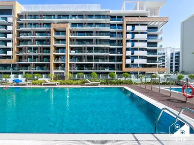 a swimming pool in front of a large apartment building at Modern Comfort Studio Relax & Unwind in Style in Dubai