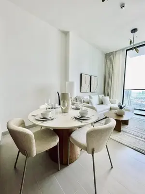 a white living room with a table and chairs at Citylight 1br Escape Gym, Pool And Free Parking! in Dubai