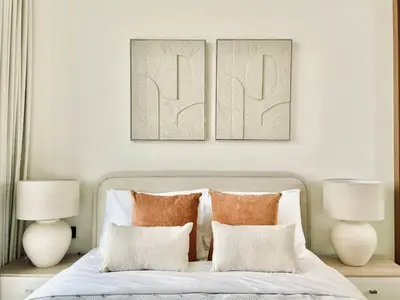 a bedroom with two pictures above a bed with pillows at Citylight 1br Escape Gym, Pool And Free Parking! in Dubai