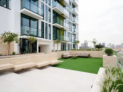 an apartment patio with benches and a green lawn at Citylight 1br Escape Gym, Pool And Free Parking! in Dubai