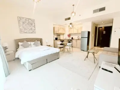 a white bedroom with a bed and a kitchen at SUPERIOR STAY High Floor, Stylish Studio in Business Bay in Dubai