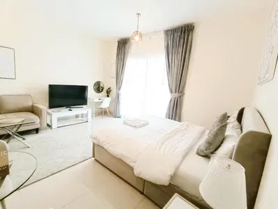 a white room with a bed and a television at SUPERIOR STAY High Floor, Stylish Studio in Business Bay in Dubai