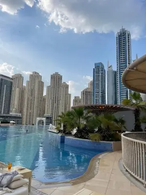 a large swimming pool in a city with tall buildings at Luxury in Dubai Marina Dining Pool Day & Beaches in Dubai