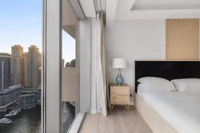 a bedroom with a bed and a large window at Luxury in Dubai Marina Dining Pool Day & Beaches in Dubai