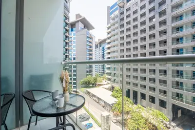a balcony with a table and chairs and buildings at GuestReady – Infinity Pool and Beach l Palm in Dubai
