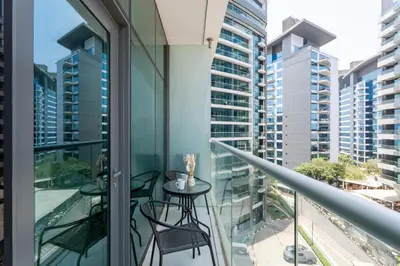 a balcony with a table and chairs and buildings at GuestReady – Infinity Pool and Beach l Palm in Dubai