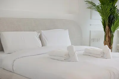 a white bed with white towels on it at Unreal Patio Private beach Sea View 1BR in Dubai