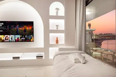 a bedroom with a bed and a tv on a wall at Unreal Patio Private beach Sea View 1BR in Dubai