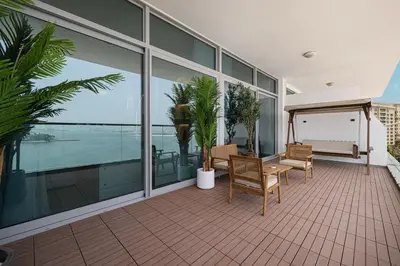 a balcony with a table and chairs and windows at Unreal Patio Private beach Sea View 1BR in Dubai