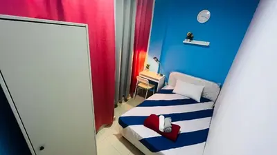 a small room with a bed with a blue wall at Divine Partition Room Barsha Heights Tecom in Dubai