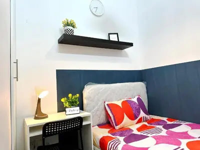a bedroom with a bed and a desk with a clock at Magnificent Partition Room in Barsha Heights Tecom in Dubai