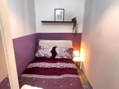 a small bed in a room with a purple wall at Excellent Partition Room In Barsha Heights Tecom in Dubai