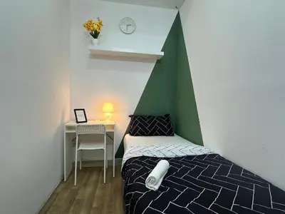 a bedroom with a bed with a green and white wall at Incredible Partition Room In Barsha Heights Tecom in Dubai