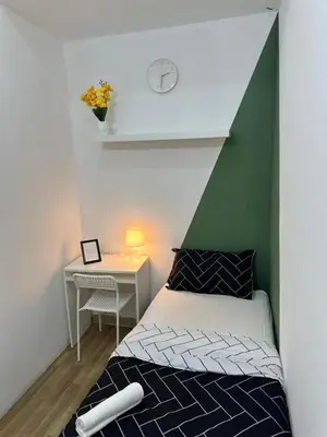 a bedroom with a bed and a table with a clock at Incredible Partition Room In Barsha Heights Tecom in Dubai