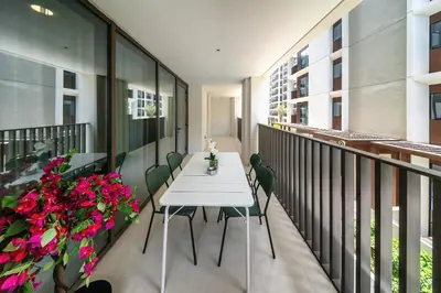 a balcony with a white table and chairs and flowers at Spacious 3BD apartment at Creek Beach, Dubai in Dubai