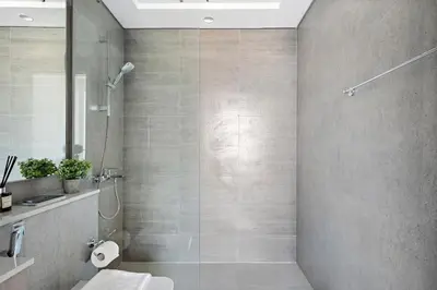 a bathroom with a shower with a toilet and a sink at VayK - Large 1BR Near Hospital and Mall in Dubai