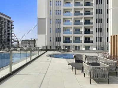 a patio with chairs and a pool on a building at VayK - Large 1BR Near Hospital and Mall in Dubai