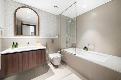 a bathroom with a tub and a toilet and a sink at VayK - Classy 1BR Near the Lagoon in Creek Harbour in Dubai