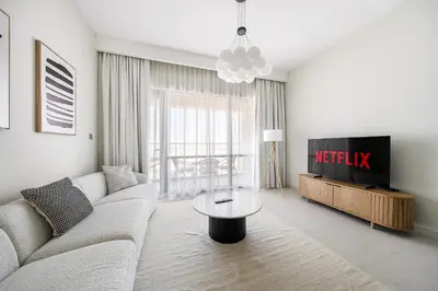 a living room with a couch and a tv at VayK - Classy 1BR Near the Lagoon in Creek Harbour in Dubai