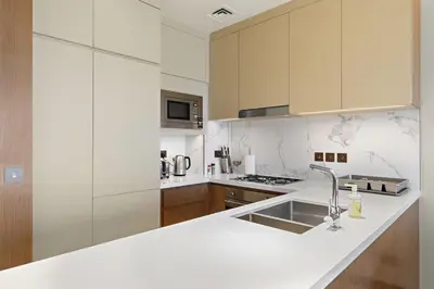 a white kitchen with a sink and a counter at VayK - Exceptional 2BR at Address Dubai Opera in Dubai
