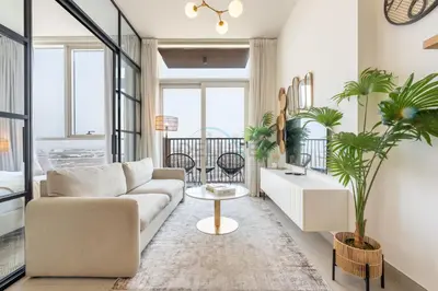 a living room with a couch and a table at Furnished 1BR Near Dubai Hills Park, Close to the Iconic Dubai Hills Mall, Only 15 Minutes from Burj Khalifa, Collective 20 Tower B, Dubai Hills by Deluxe Holiday Homes in Dubai