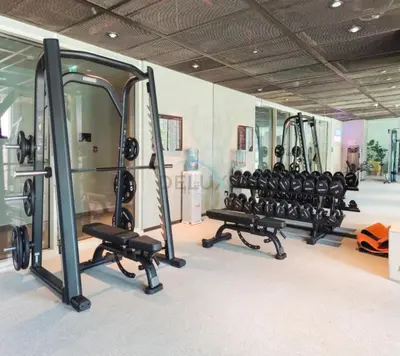 a gym with a row of treadmills and mirrors at Furnished 1BR Near Dubai Hills Park, Close to the Iconic Dubai Hills Mall, Only 15 Minutes from Burj Khalifa, Collective 20 Tower B, Dubai Hills by Deluxe Holiday Homes in Dubai