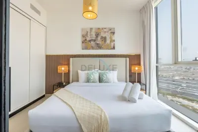 a bedroom with a large white bed and a window at Furnished 1BR Near Dubai Hills Park, Close to the Iconic Dubai Hills Mall, Only 15 Minutes from Burj Khalifa, Collective 20 Tower B, Dubai Hills by Deluxe Holiday Homes in Dubai