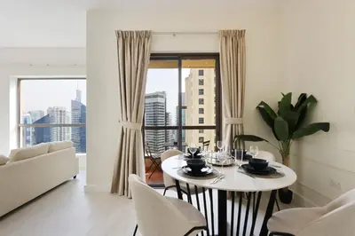 a dining room with a table and chairs and a window at Upgraded 1BHK with Stunning Marina Views in Dubai