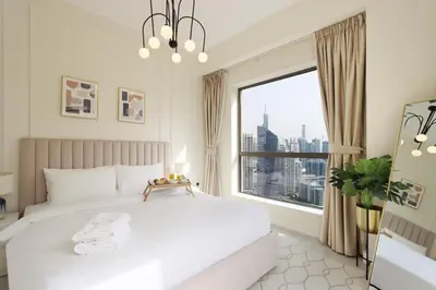 a bedroom with a white bed and a large window at Upgraded 1BHK with Stunning Marina Views in Dubai