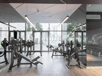 a gym with rows of exercise equipment and large windows at High-Floor Skyline View Near Safa Park and Godolphin Stables with Easy Access to Dubai Mall and Canal, Aykon City 2 Tower C, Business Bay by Deluxe Holiday Homes in Dubai